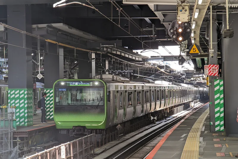 Ein Zug der Yamanote-Linie am Bahnhof Shibuya, direkt unter dem Turm